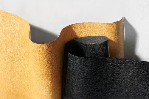 Close-up of two curling sheets of textured textile, one yellow and one black.