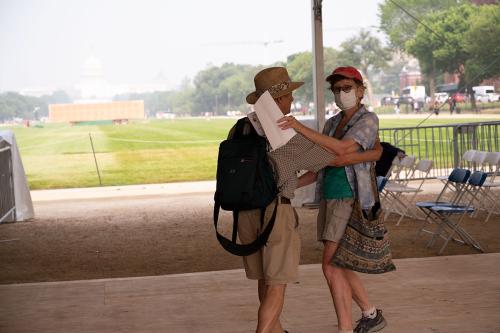 A couple dances on an outdoor dance floor, with the U.S. Capitol Building barely visible through smoky haze in the distance.