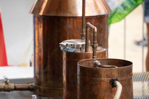 Three shiny copper pots connected by copper pipes.