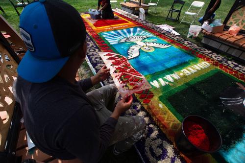 A Guate-Maya D.C. team member looks over the first alfombra’s state after the Festival’s first storm.