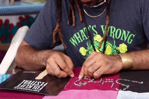 Close-up on a person embroidering at a table.