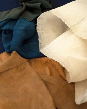 Close-up on silk fabric in white, mustard, deep turquoise, and forest green.