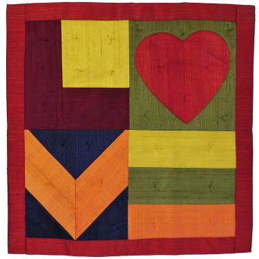 Square fabric quilt with stylized letters spelling LOVE. The O is a red heart.