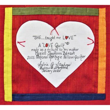 Square quilt with handwritten words on a white heart: “SHE... taught me LOVE”. A LOVE Quilt made as a tribute to my mother Mozell Stephens Benson, 2001 National Heritage Fellow Quilter. Signed, Sylvia G. Stephens, Hyattsville, Maryland, January 2020. 