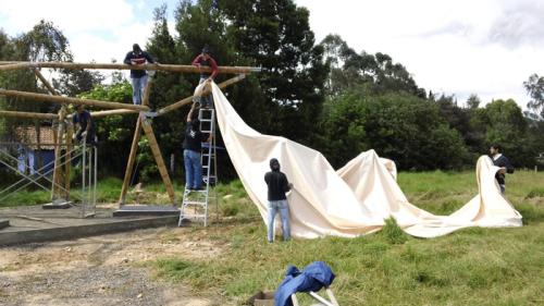 Pulling white canvas over bamboo frame, photo by and courtesy of Francisco Quiñónez