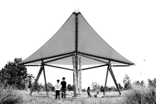 Children under finished guadua tent.