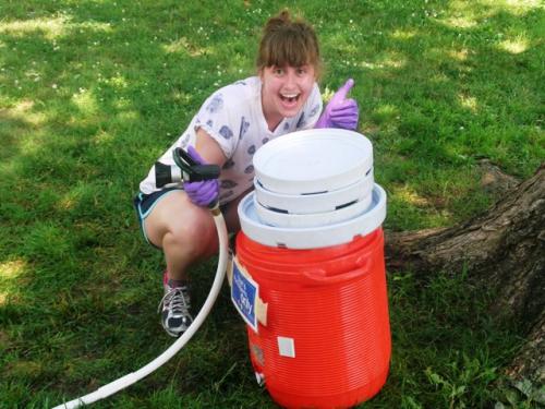 Interns cleaned water coolers that will hold cool beverages for festival staff, volunteers, and participants. Here, intern Daisy Zeijlon rinses out a water cooler.