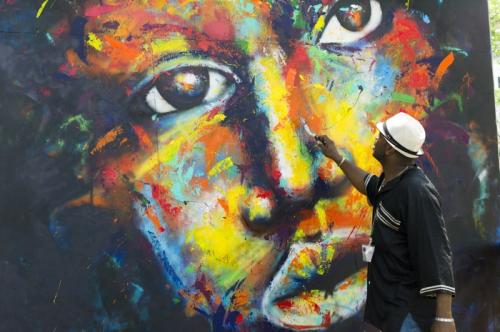 Jay Coleman paints a live portrait mural in the Citified program area. Photo by Carsten Schmidt, Smithsonian Institution