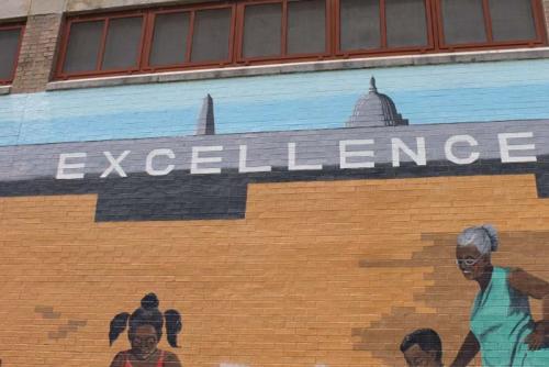 A mural decorating the Benning Park Community Center expresses the importance of excellence to the neighborhood.