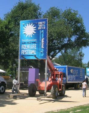 Technical staff do some heavy lifting to relocate a Festival sign.