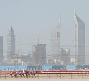 Camel riders in the foreground and skyscrapers in the background.