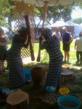 Braimah Shietu and Rukayu Amidu work in unison to demonstrate the shea butter production process in the Peace Corps program of the Festiva