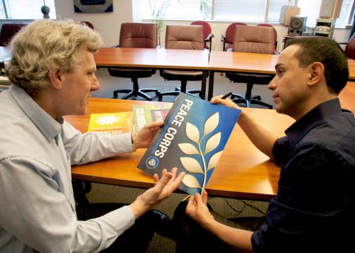 Peace Corps curator discusses layout with Senior Designer Josue Castilleja
