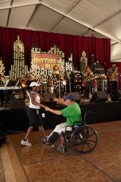 R&B program intern Charise Richards dances with a visitor as the Monitors perform.