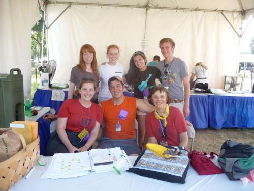 Betty Belanus and her interns convene at the Volunteer Tent for an afternoon meeting. Standing, left to right: Interns Hester Clarke, Casey Carlson and Lauren Lauzon, and Accessibility Aide Brendon Ziebarth; seated, left to right: Interns Meghan Burke and