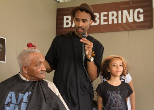 Dusan Grante, creative director of Arthur Christine Salon, describes the cut he is giving to Mr. Diggs, a Baltimore Arabber whose family has been participating in the Smithsonian Folklife Festival for since 1967. Photo by Pruitt Allen, Ralph Rinzler Folkl