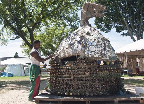 Isaac Kibe working on the Kitengela glass hut on closing day of the Folklife Festival. Photo by Heather Caverhill, Ralph Rinzler Folklife Archives and Collections, Smithsonian Institution