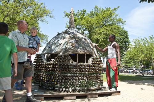Isaac Kibe puts finishing touches on the Kitengela glass shed on the final day of the Folklife Festival. Photo by Hillary Cleary, Ralph Rinzler Folklife Archives