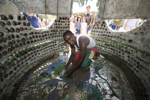 Isaac Kibe puts finishing touches on the Kitengela glass hut.
