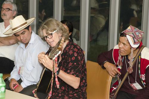 As participants, presenters, and staff took shelter inside the museum, the festivities continued in the green room. Wachiperi presenter Holly Wissler took a turn on the Cusco weavers' sixteen-string guitar. Photo by Josh Weilepp, Ralph Rinzler Folklife Ar