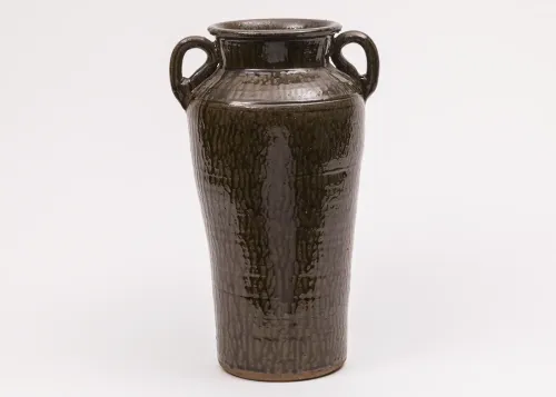 A tall, dark brown glazed vessel with two rounded handles on either side of the mouth.