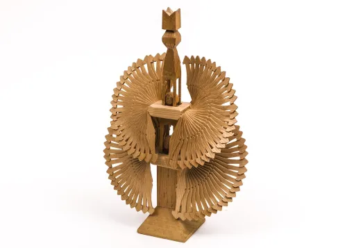 An intricate wooden carving features a center pillar of geometric shapes, with two levels of semi-circle fan structures extending from either side.