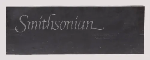 A rectangular slab of black slate features the word “Smithsonian” carved in elegant font.