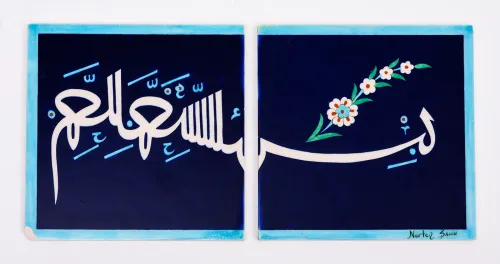 Two square ceramic tiles decorated with a design of white Arabic calligraphy and a spray of white flowers that extends across both tiles, set off against a navy-blue background with light blue border.